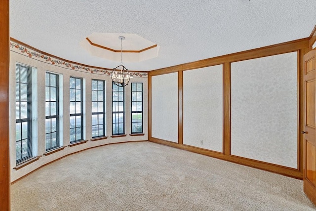 7254 Hialeah Cir W, North Richland Hills, TX 76182 - empty room featuring a chandelier, carpet, a textured ceiling, crown molding, and a raised ceiling