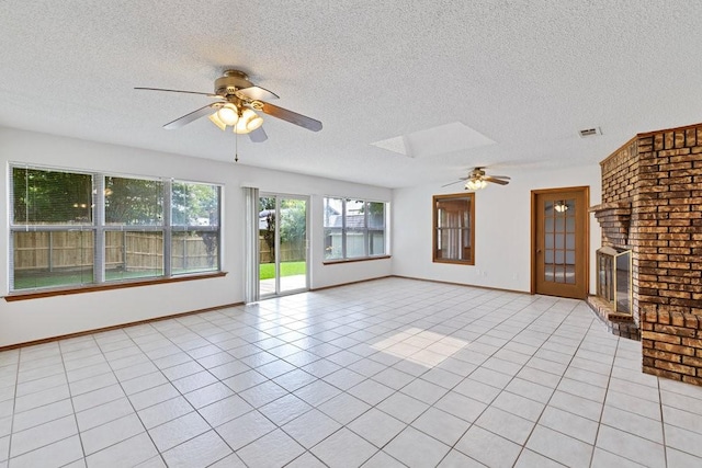 7254 Hialeah Cir W, North Richland Hills, TX 76182 - unfurnished living room with ceiling fan, a fireplace, a textured ceiling, a skylight, and light tile patterned floors