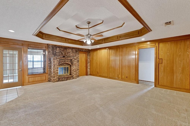 7254 Hialeah Cir W, North Richland Hills, TX 76182 - unfurnished living room with a raised ceiling, a textured ceiling, a ceiling fan, wood walls, and a fireplace