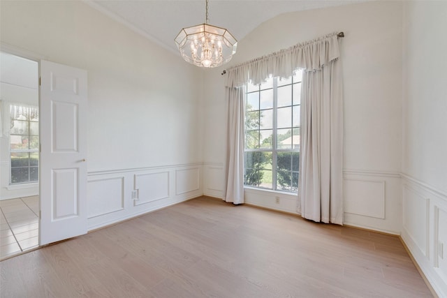 11275 Old Military Trl, Forney, TX 75126 - empty room with a chandelier, a decorative wall, light wood-type flooring, wainscoting, and lofted ceiling