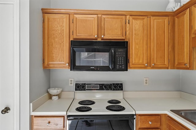 1450 Hampton Rd, Grapevine, TX 76051 - kitchen featuring white electric range oven, black microwave, light countertops, and tile patterned floors