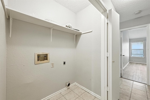 1450 Hampton Rd, Grapevine, TX 76051 - washroom with hookup for an electric dryer, washer hookup, a textured ceiling, and light tile patterned flooring