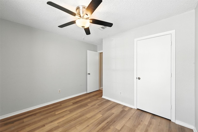 1450 Hampton Rd, Grapevine, TX 76051 - unfurnished bedroom featuring wood finished floors, a textured ceiling, and a ceiling fan