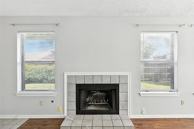 1450 Hampton Rd, Grapevine, TX 76051 - detailed view of a tile fireplace, a textured ceiling, and wood finished floors