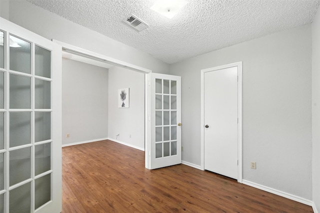 1450 Hampton Rd, Grapevine, TX 76051 - spare room featuring french doors, wood finished floors, and a textured ceiling