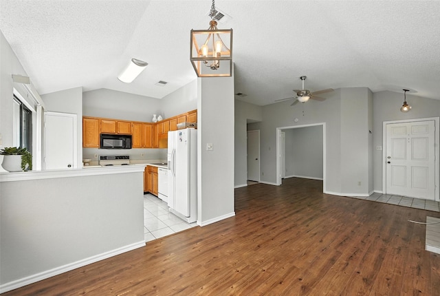 1450 Hampton Rd, Grapevine, TX 76051 - kitchen featuring lofted ceiling, white appliances, open floor plan, light wood-type flooring, and hanging light fixtures