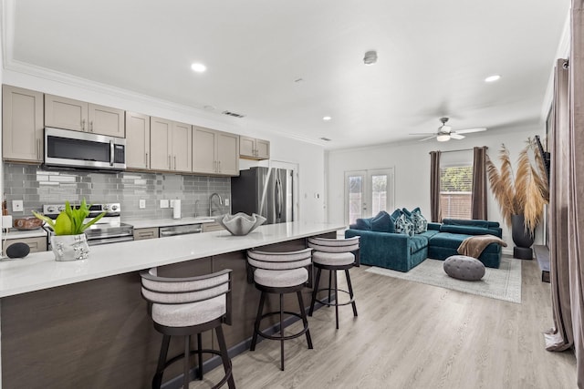 3144 Harmon St, Dallas, TX 75215 - kitchen featuring appliances with stainless steel finishes, a kitchen bar, open floor plan, ornamental molding, and decorative backsplash