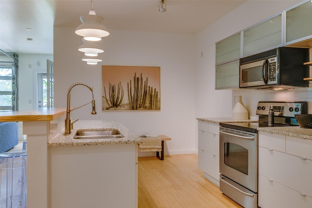 1111 S Akard St Unit 310, Dallas, TX 75215 - kitchen featuring stainless steel electric range oven, black microwave, decorative light fixtures, light stone counters, and light wood-style flooring