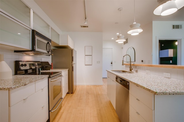 1111 S Akard St Unit 310, Dallas, TX 75215 - kitchen with stainless steel appliances, backsplash, light wood finished floors, and an island with sink