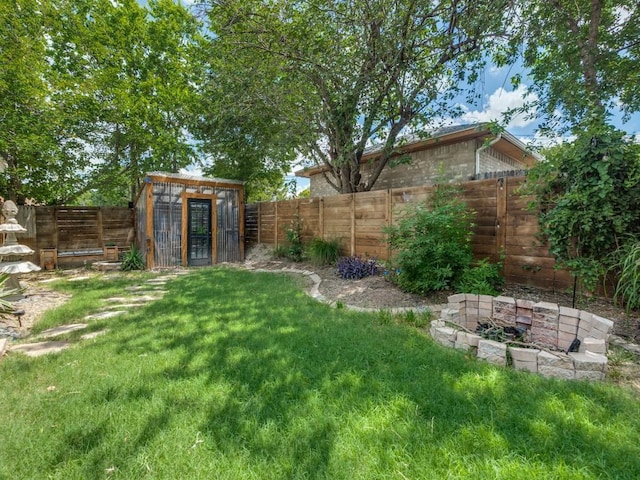 2719 W 12th St, Dallas, TX 75211 - fenced backyard featuring a fire pit, exterior structure, and an outbuilding