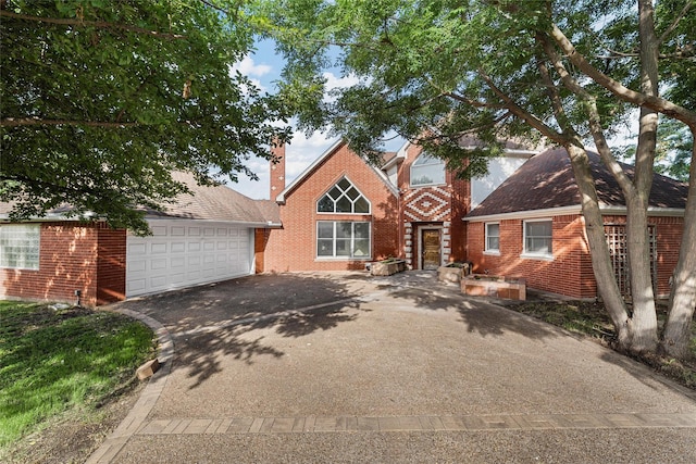 308 Westlane Cir, Woodway, TX 76712 - view of front of home with driveway, brick siding, a garage, and a chimney