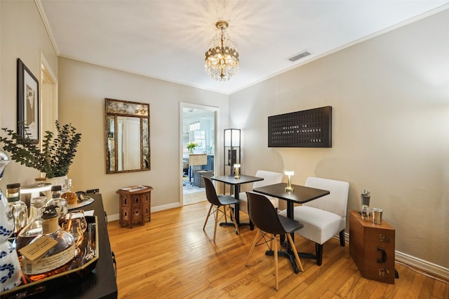 1147 N Windomere Ave, Dallas, TX 75208 - dining area featuring a chandelier, ornamental molding, and light wood-style flooring