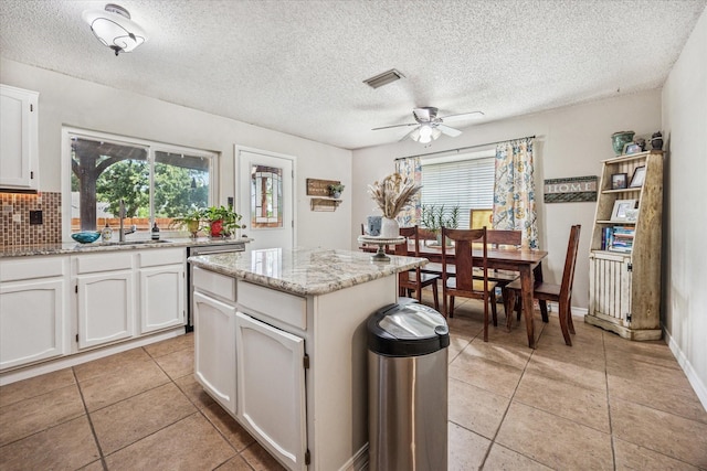 4201 Ravenhill Ln, Arlington, TX 76016 - kitchen featuring dishwasher, plenty of natural light, light tile patterned floors, and a textured ceiling