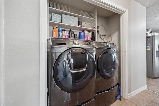 4201 Ravenhill Ln, Arlington, TX 76016 - laundry area featuring washer and dryer, tile patterned floors, and a textured ceiling