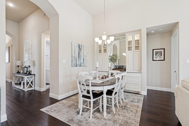14845 Belclaire Ave, Aledo, TX 76008 - dining area featuring dark wood-type flooring, arched walkways, and a towering ceiling