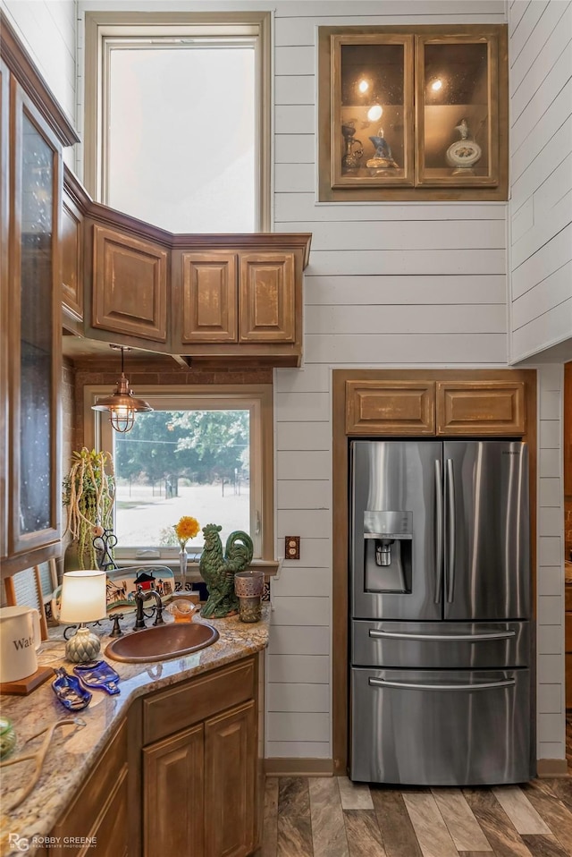 9900 Myrtis Texas Line Rd, Vivian, LA 71082 - kitchen with stainless steel refrigerator with ice dispenser, wooden walls, light stone countertops, and brown cabinets