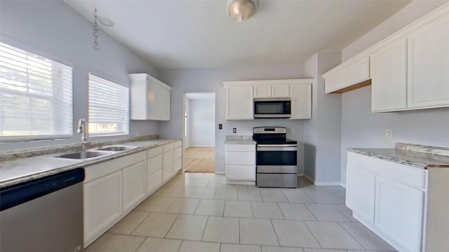 2700 S Jones St, Fort Worth, TX 76104 - kitchen featuring appliances with stainless steel finishes, white cabinets, light countertops, and light tile patterned flooring