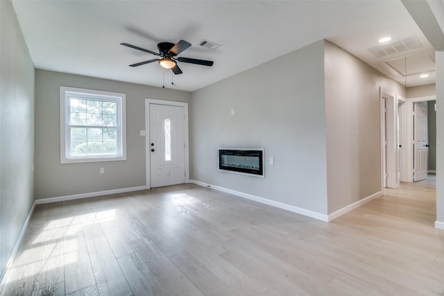 331 Andover Dr, Mesquite, TX 75149 - foyer entrance featuring light wood-type flooring, a ceiling fan, and a glass covered fireplace
