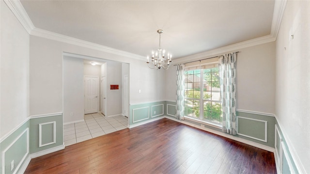 4009 Bickmore Ln, Fort Worth, TX 76244 - unfurnished room featuring a chandelier, ornamental molding, wood finished floors, a wainscoted wall, and a decorative wall