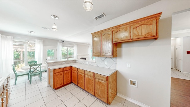 4009 Bickmore Ln, Fort Worth, TX 76244 - kitchen with light countertops, a peninsula, tasteful backsplash, hanging light fixtures, and light tile patterned floors