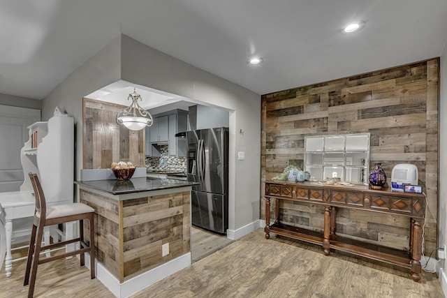 2020 Skylark Dr, Dallas, TX 75216 - kitchen featuring fridge with ice dispenser, light wood-style flooring, wooden walls, backsplash, and recessed lighting