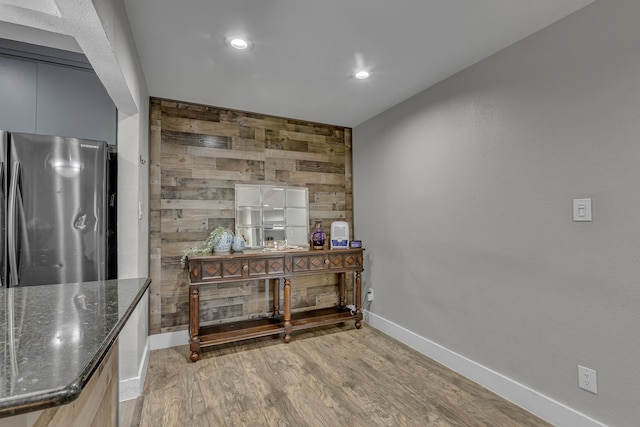 2020 Skylark Dr, Dallas, TX 75216 - kitchen view of freestanding refrigerator, wooden walls, light wood-style floors, dark stone countertops, and recessed lighting