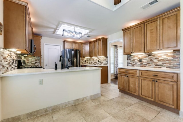 2514 Golden Oaks Dr, Garland, TX 75044 - kitchen featuring refrigerator with ice dispenser, decorative backsplash, stainless steel microwave, a peninsula, and stove