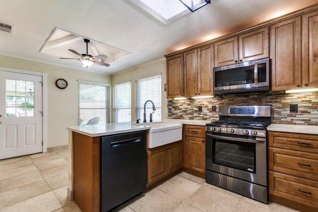 2514 Golden Oaks Dr, Garland, TX 75044 - kitchen featuring appliances with stainless steel finishes, decorative backsplash, a peninsula, plenty of natural light, and ornamental molding