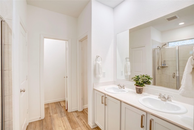 1113 Milfoil Dr, Justin, TX 76247 - bathroom with a stall shower, wood finished floors, and double vanity