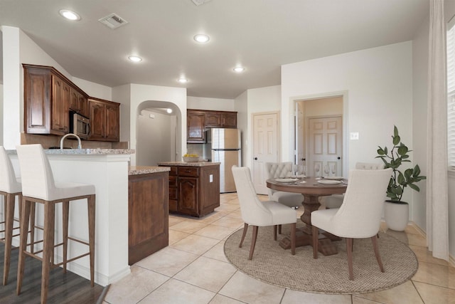 3228 Buckthorn Ln, Denton, TX 76226 - dining area with arched walkways, light tile patterned floors, and recessed lighting