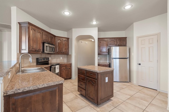 3228 Buckthorn Ln, Denton, TX 76226 - kitchen with appliances with stainless steel finishes, backsplash, a kitchen island, light countertops, and recessed lighting