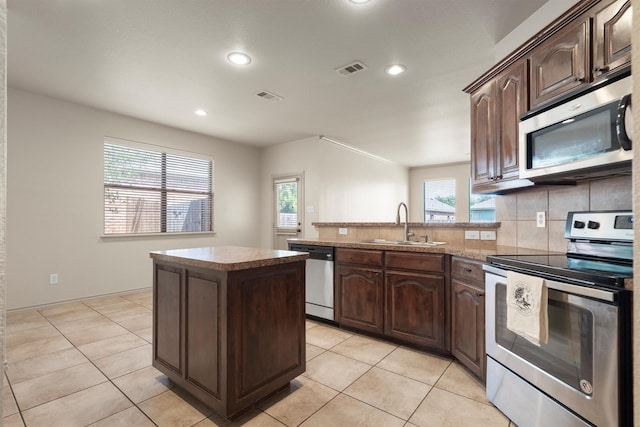 3228 Buckthorn Ln, Denton, TX 76226 - kitchen with appliances with stainless steel finishes, recessed lighting, a peninsula, tasteful backsplash, and a kitchen island