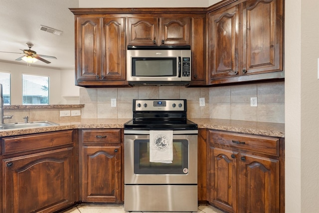 3228 Buckthorn Ln, Denton, TX 76226 - kitchen with stainless steel appliances, a ceiling fan, tasteful backsplash, and light stone counters