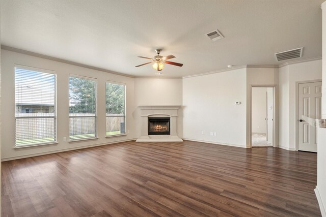 3228 Buckthorn Ln, Denton, TX 76226 - unfurnished living room featuring a ceiling fan, dark wood-style flooring, ornamental molding, and a warm lit fireplace