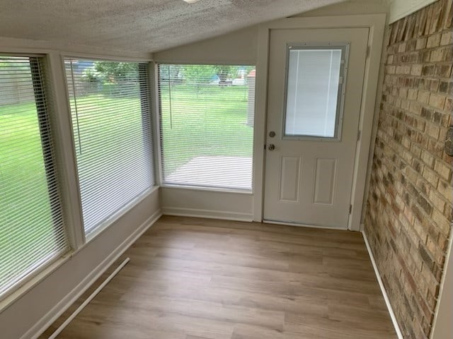 304 Lakeview St, Whitehouse, TX 75791 - entryway featuring brick wall, lofted ceiling, light wood-style floors, and a textured ceiling