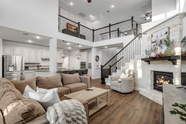 3804 Driftwood Ln, Northlake, TX 76226 - living area featuring ceiling fan, a stone fireplace, dark wood-style flooring, recessed lighting, and a towering ceiling
