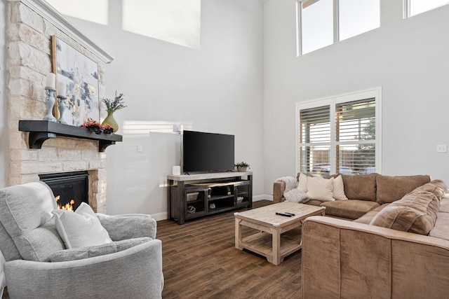 3804 Driftwood Ln, Northlake, TX 76226 - living area featuring dark wood-type flooring, a stone fireplace, a towering ceiling, and plenty of natural light