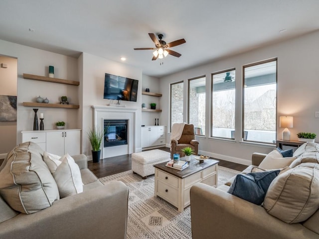 2112 Deer Run, Gunter, TX 75058 - living area with light wood-type flooring, ceiling fan, a glass covered fireplace, and built in features