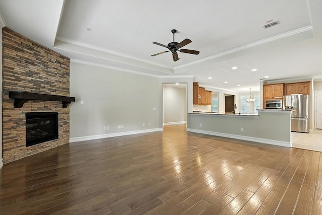6371 Walnut Hill Ct, Frisco, TX 75036 - unfurnished living room with a ceiling fan, a tray ceiling, a fireplace, hardwood / wood-style flooring, and recessed lighting
