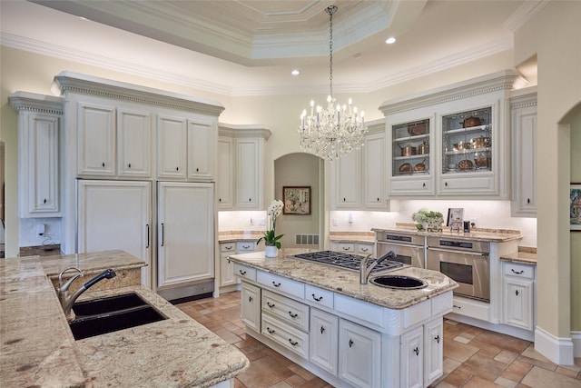 5 Savannah Ridge Dr, Frisco, TX 75034 - kitchen featuring stainless steel appliances, a kitchen island, light stone countertops, arched walkways, and ornamental molding