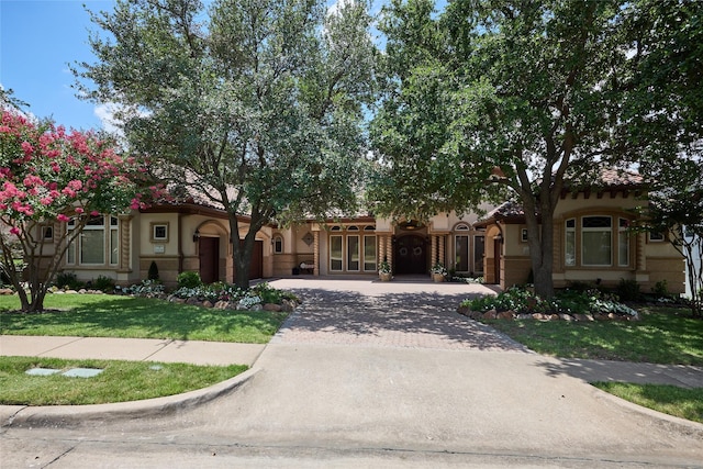 5 Savannah Ridge Dr, Frisco, TX 75034 - mediterranean / spanish house featuring decorative driveway, a front lawn, stucco siding, a garage, and french doors