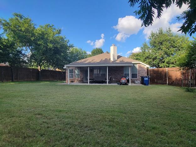 700 Auburndale Dr, Euless, TX 76040 - back of house featuring a fenced backyard and a chimney