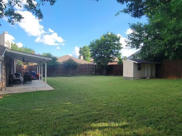 700 Auburndale Dr, Euless, TX 76040 - fenced backyard featuring a storage shed and a patio