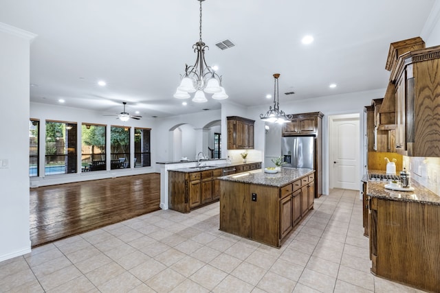 4205 Midpark Ln, Plano, TX 75074 - kitchen with stainless steel fridge, ceiling fan, recessed lighting, arched walkways, and light tile patterned flooring