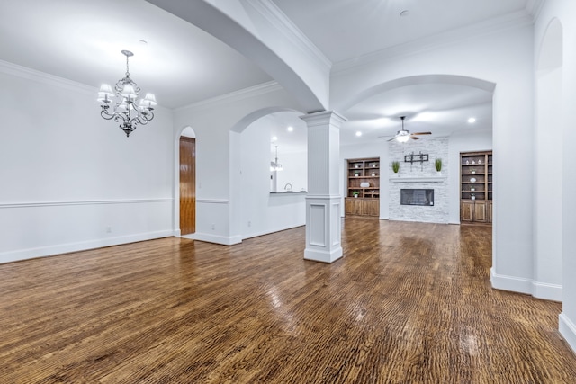 4205 Midpark Ln, Plano, TX 75074 - unfurnished living room featuring ceiling fan, a large fireplace, dark wood-style flooring, crown molding, and a chandelier