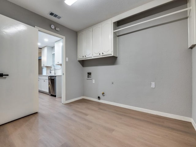 1044 Peach Ln, Desoto, TX 75115 - laundry area featuring hookup for a gas dryer, light wood finished floors, hookup for a washing machine, and cabinet space