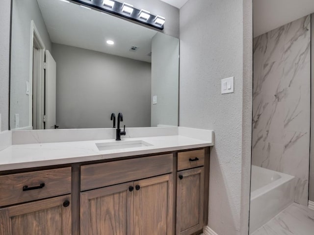1044 Peach Ln, Desoto, TX 75115 - bathroom with vanity, marble look tiles, a textured wall, and tub / shower combination