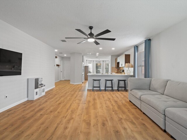 1545 Knottingham Dr, Little Elm, TX 75068 - living room featuring ceiling fan, light wood finished floors, recessed lighting, and a textured ceiling
