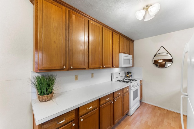 1238 Caladium Dr, Mesquite, TX 75149 - kitchen with white appliances, brown cabinets, and light countertops
