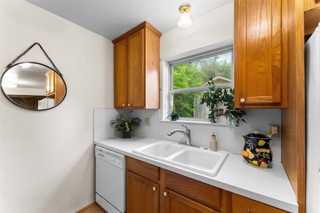1238 Caladium Dr, Mesquite, TX 75149 - kitchen featuring white dishwasher, light countertops, and brown cabinetry